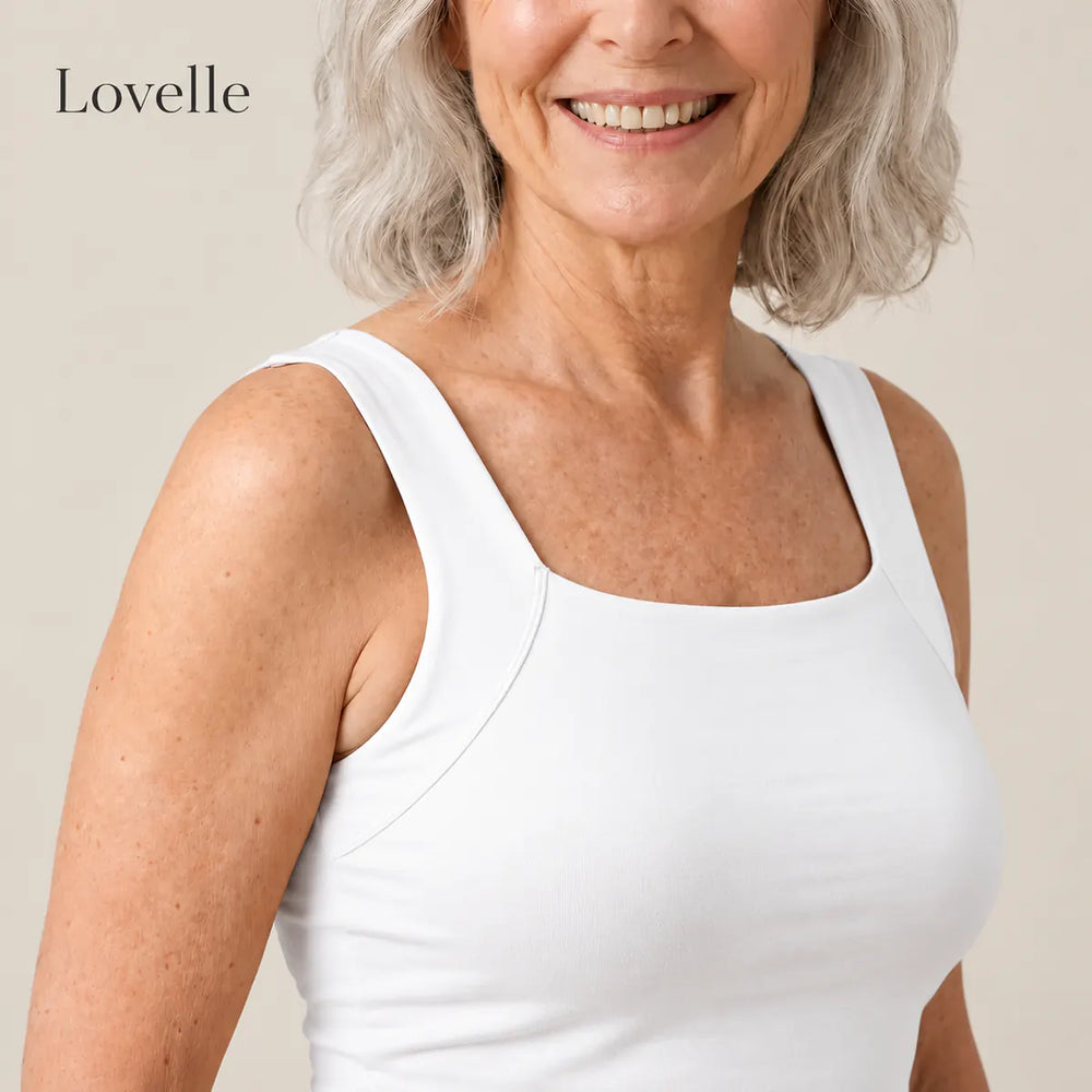 Smilende kvinne med sølvgrått hår i Lovelle Ease singlet med innebygd BH i hvit, firkantet halsåpning og brede stropper